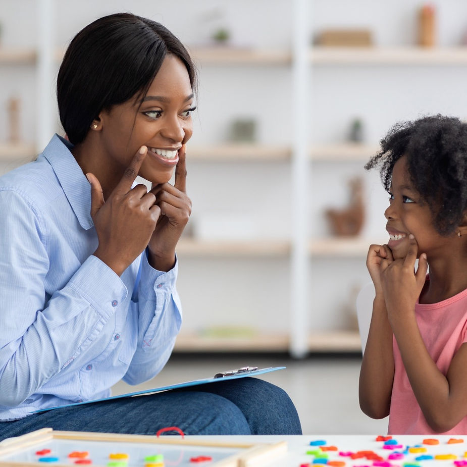 A black therapist teaching behavioral and adaptive skills to a girl